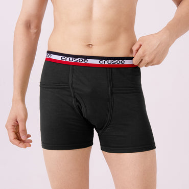 Person wearing black trunk with a visible brand logo on a plain background