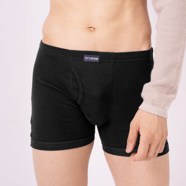 Person wearing black trunk with a visible brand logo on a light gray background